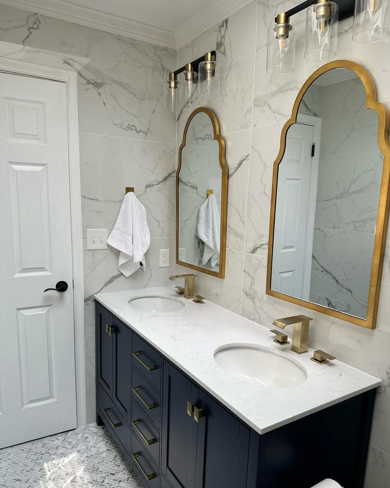 Double vanity bathroom with gold-framed mirrors