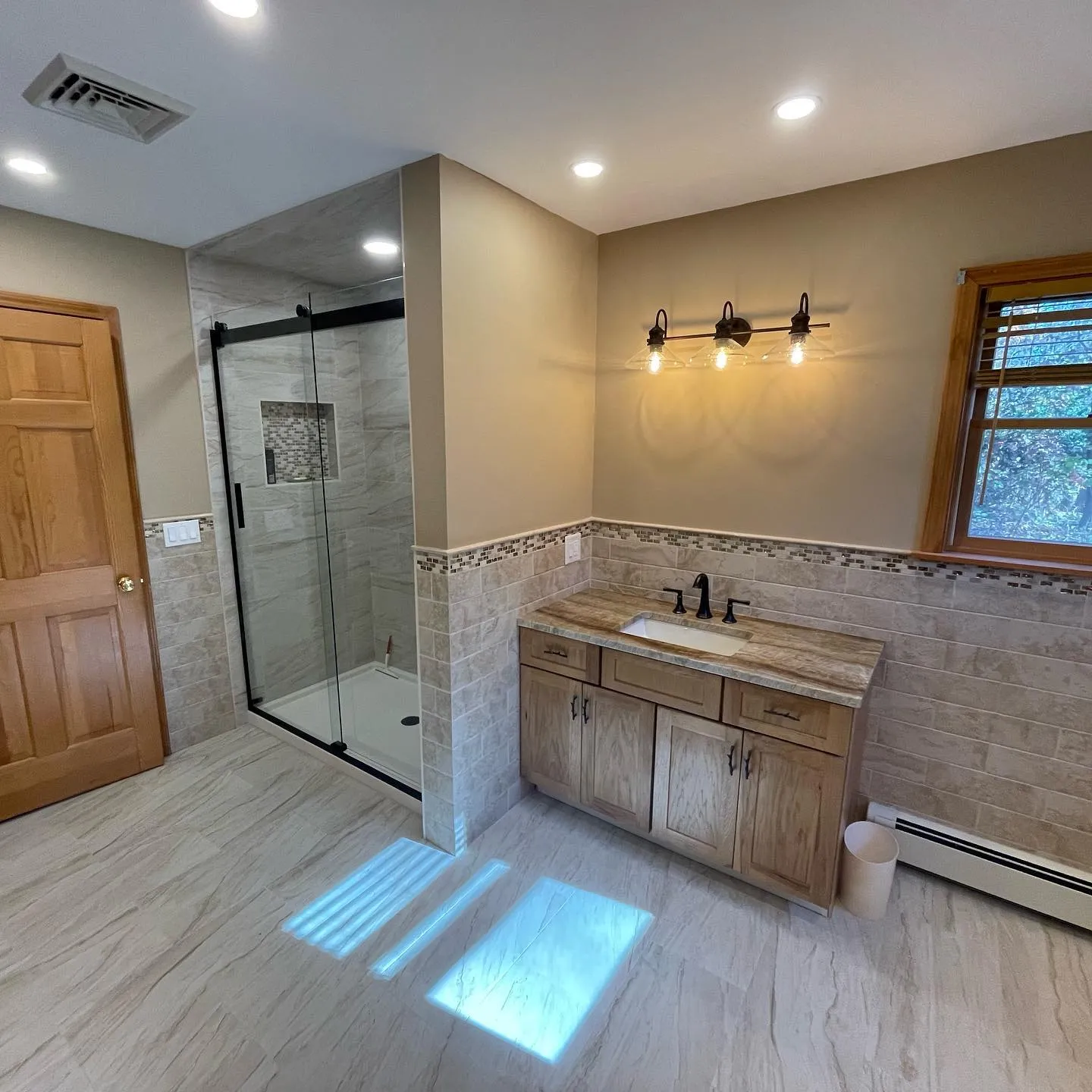 Spacious bathroom with glass shower and stone tile